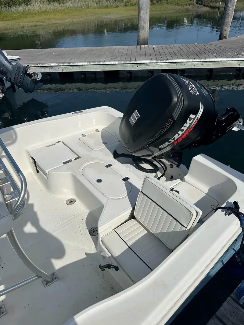 Slide: The Image of 2007 Pioneer 220 Bay Sport boat with Suzuki outboard motor docked by the water. - 6