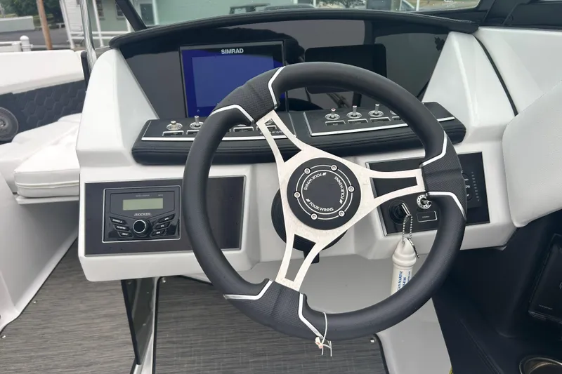 Slide: The Image of 2025 Four Winns H2 OB boat dashboard with steering wheel and control panel. - 16