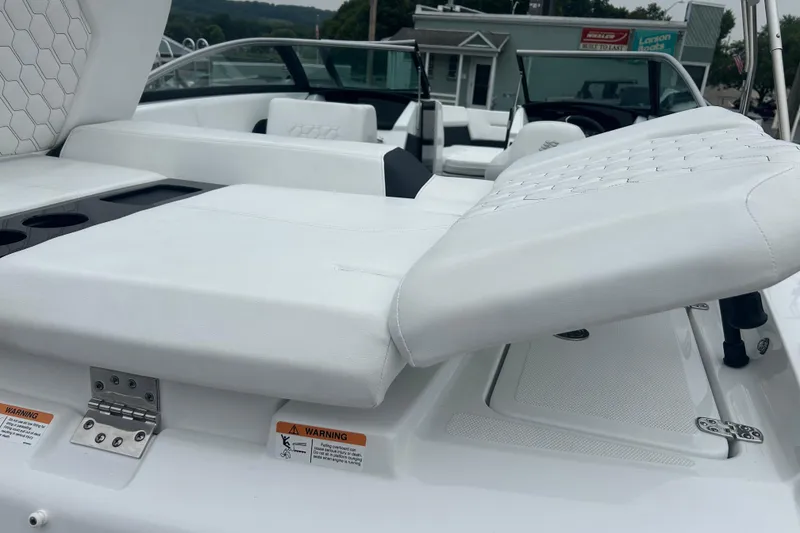 Slide: The Image of 2025 Four Winns H2 OB boat interior with white cushioned seating and cup holders. - 19