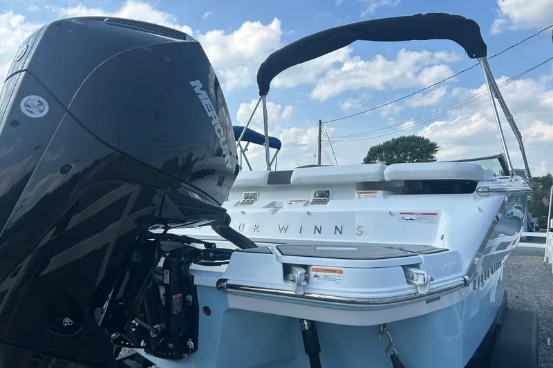 Slide: The Image of 2025 Four Winns H2 OB boat with Mercury outboard motor, under a clear blue sky. - 2