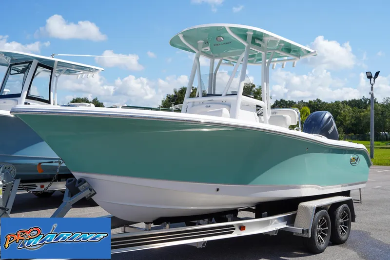 Slide: The Image of 2025 Sea Hunt Ultra 219 boat on trailer, light blue hull, sunny day. - 0
