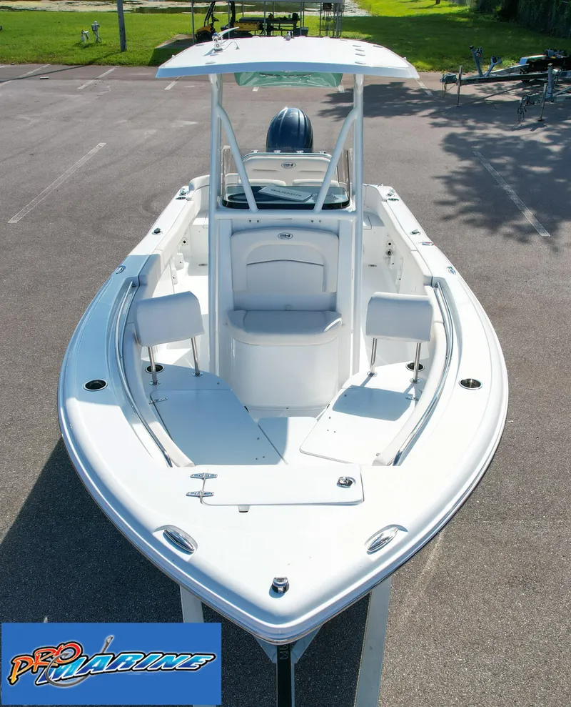 Slide: The Image of 2025 Sea Hunt Ultra 219 boat, white exterior, parked on pavement, front view. - 14