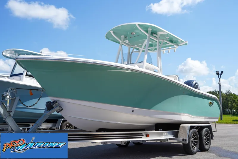 Slide: The Image of 2025 Sea Hunt Ultra 219 boat on trailer, light blue hull, sunny day. - 21