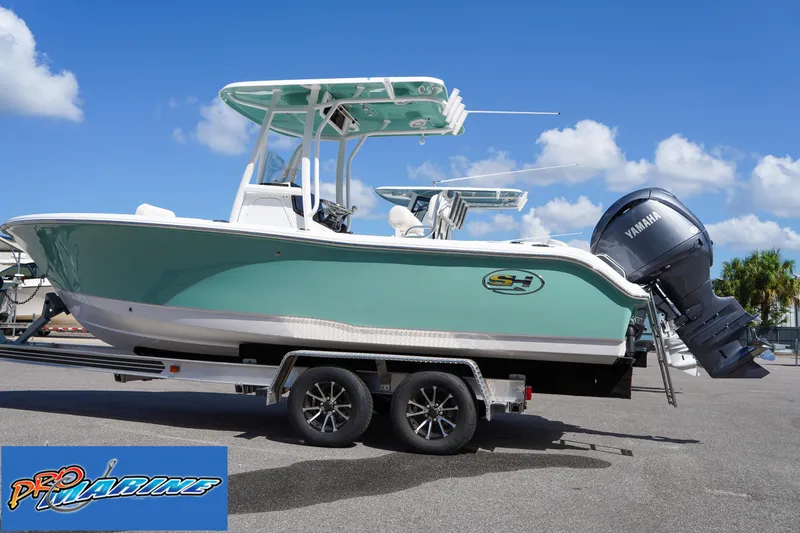 Slide: The Image of 2025 Sea Hunt Ultra 219 boat on trailer with Yamaha engine, clear sky background. - 23