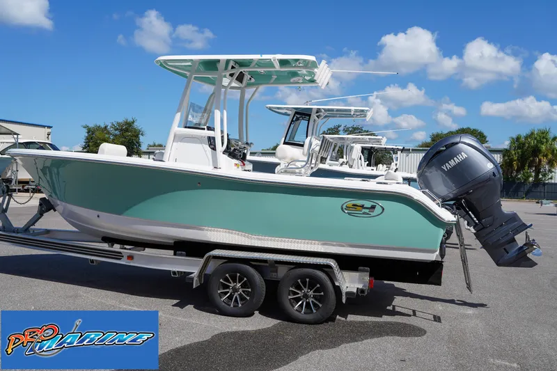 Slide: The Image of 2025 Sea Hunt Ultra 219 boat on trailer with Yamaha engine, clear sky background. - 24