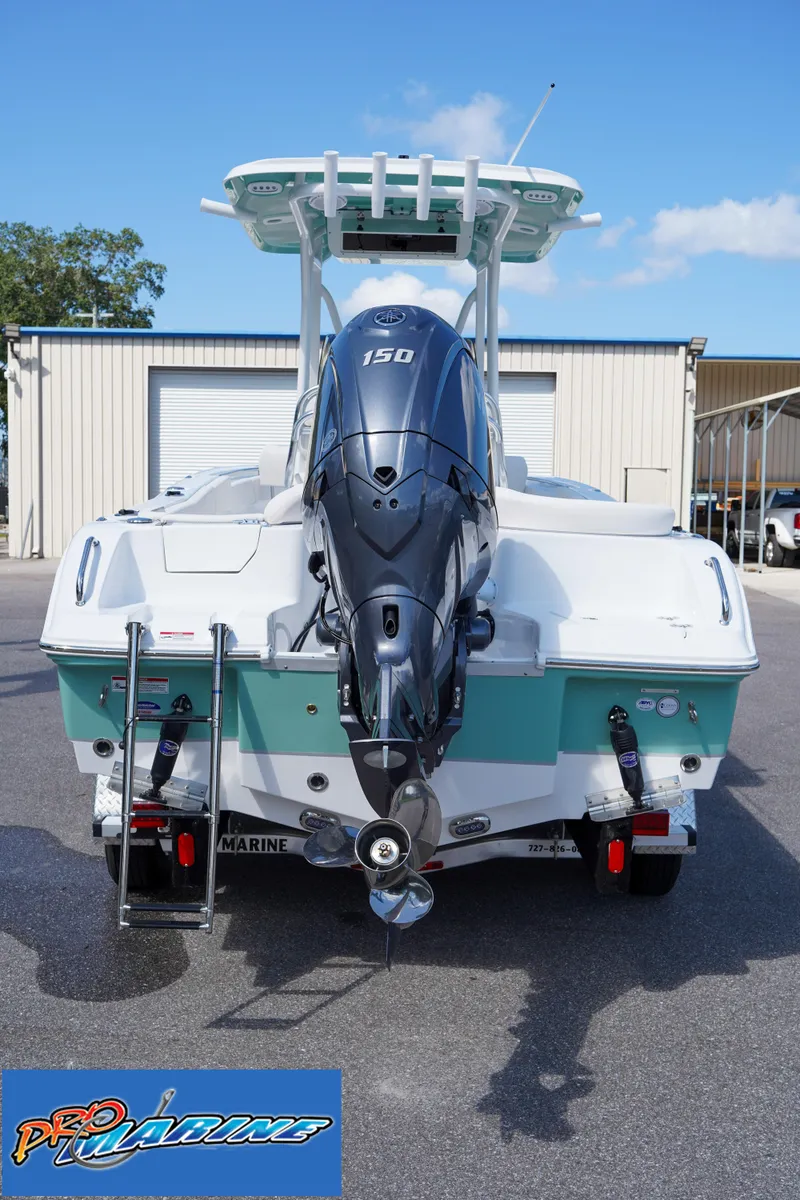 Slide: The Image of 2025 Sea Hunt Ultra 219 boat with 150 HP engine, parked outdoors. - 28
