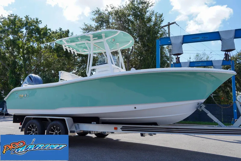 Slide: The Image of 2025 Sea Hunt Ultra 219 boat on trailer, light blue hull, outdoor setting. - 30