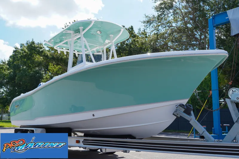 Slide: The Image of 2025 Sea Hunt Ultra 219 boat on trailer, mint green hull, sunny day. - 31