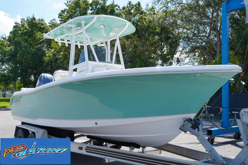 Slide: The Image of 2025 Sea Hunt Ultra 219 boat on trailer, displayed outdoors with trees in background. - 32