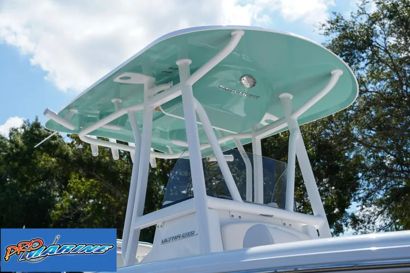 Slide: The Image of 2025 Sea Hunt Ultra 219 boat with teal T-top against a blue sky. - 39
