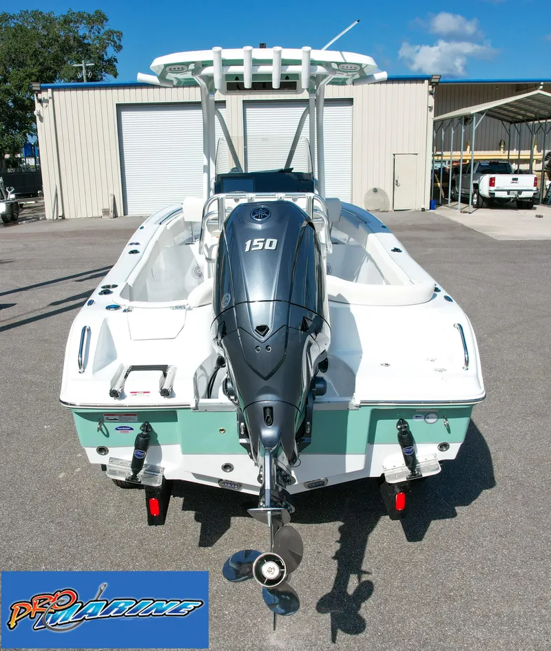 Slide: The Image of 2025 Sea Hunt Ultra 219 boat with 150 HP engine, parked outdoors. - 7