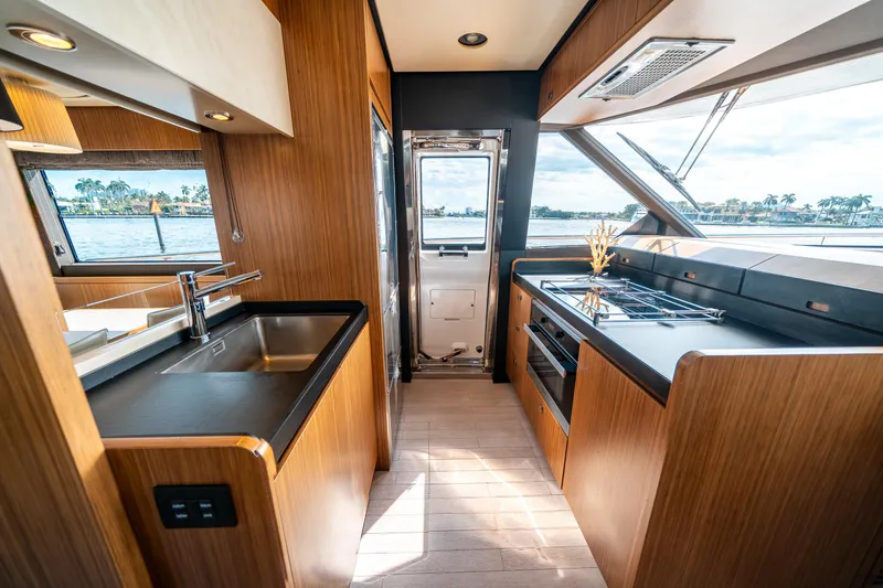 Slide: The Image of Luxurious kitchen interior of 2018 Azimut Magellano 66 yacht with modern appliances and wood finish. - 23