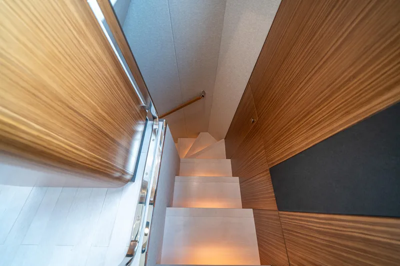 Slide: The Image of Staircase inside 2018 Azimut Magellano 66 yacht with wooden paneling and modern design. - 27