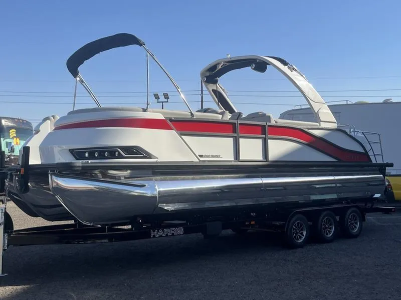 Slide: The Image of 2025 Harris Grand Mariner SL 250 pontoon boat on a trailer, featuring sleek design and modern amenities. - 2