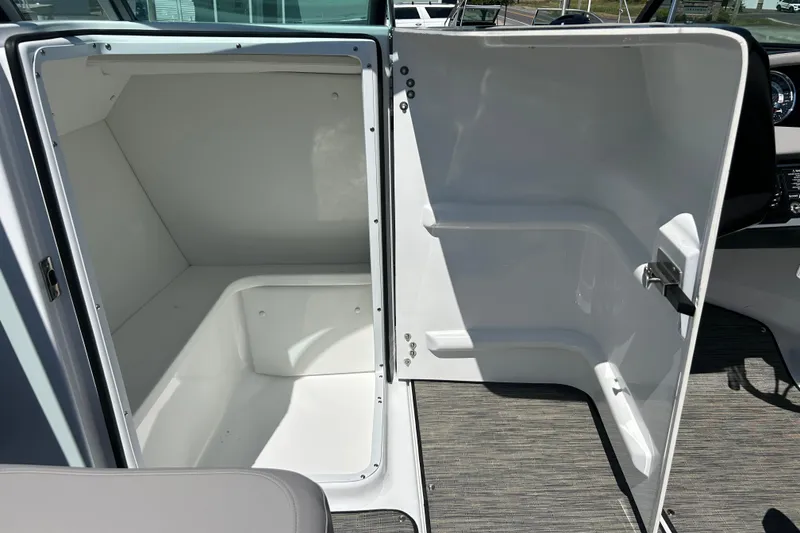 Slide: The Image of 2025 Four Winns HD3 boat interior storage compartment with open door, showcasing spacious design. - 25
