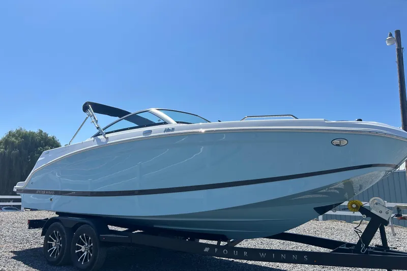 Slide: The Image of 2025 Four Winns HD3 boat on trailer under clear blue sky. - 3