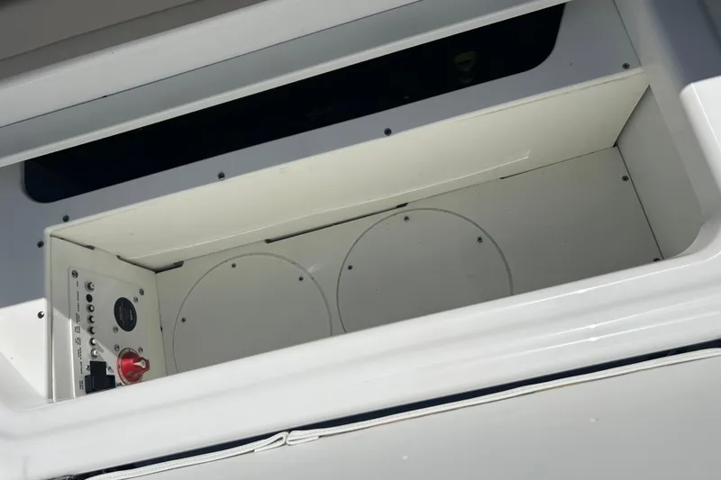 Slide: The Image of Storage compartment in 2025 Four Winns HD3 boat, featuring control panel and switches. - 42
