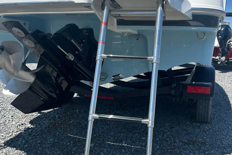 Slide: The Image of 2025 Four Winns HD3 boat stern with ladder and propeller on gravel surface. - 43