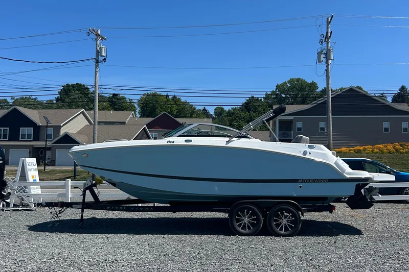 Slide: The Image of 2025 Four Winns HD3 boat on trailer, parked outdoors on gravel lot. - 5