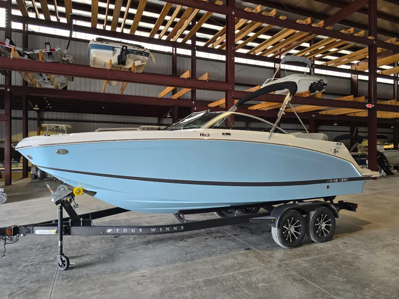 Slide: The Image of 2025 Four Winns HD3 boat in storage, light blue hull, on trailer. - 6