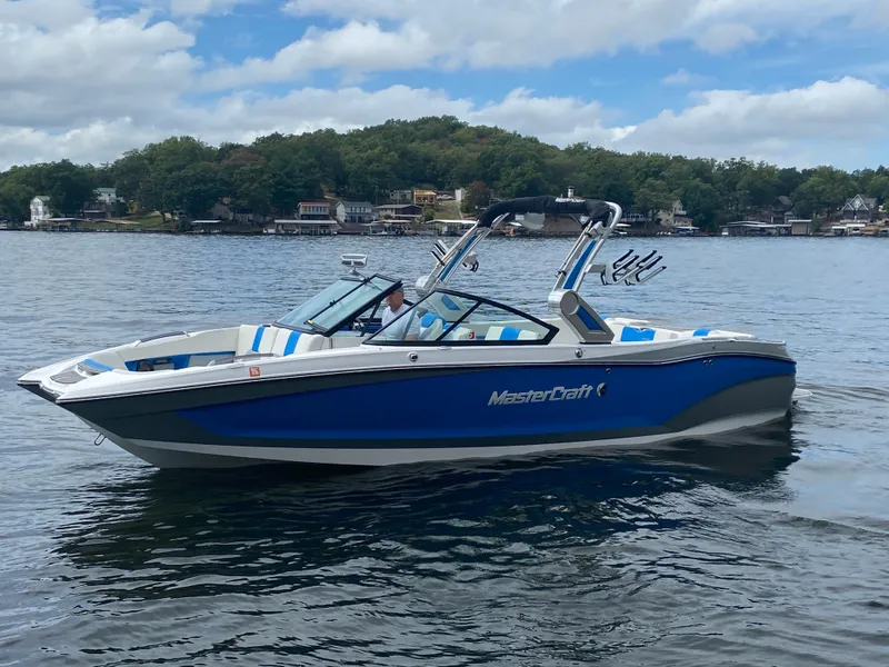 Slide: The Image of 2022 MasterCraft X26 boat on a lake with scenic background. - 44