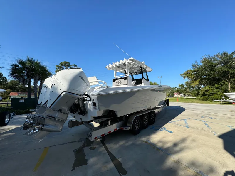 Slide: The Image of 2025 Fountain 38TE boat on trailer, parked outdoors under clear blue sky. - 13