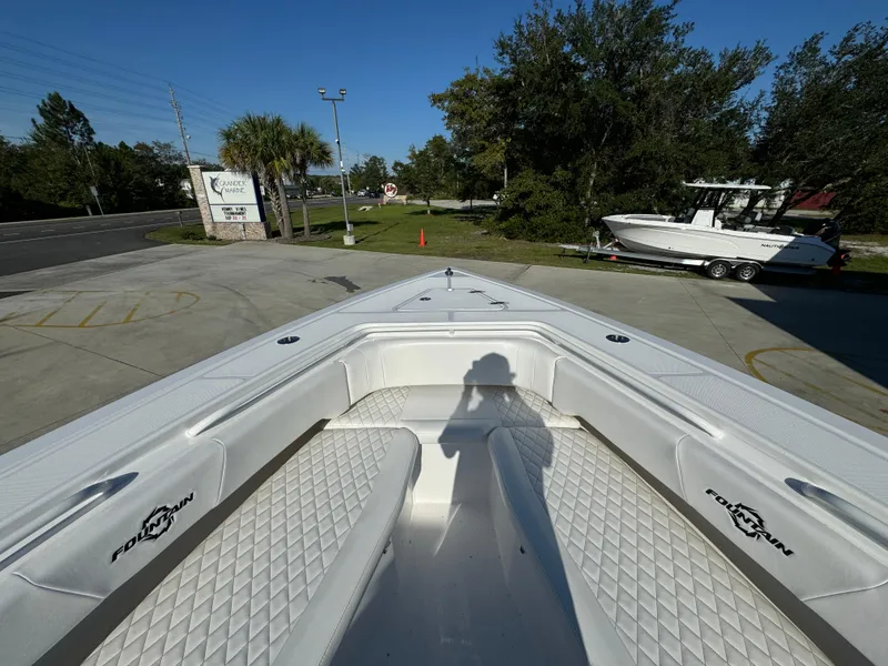 Slide: The Image of Bow view of 2025 Fountain 38TE boat with white seating and diamond pattern upholstery. - 19