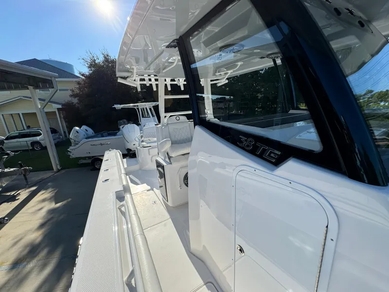 Slide: The Image of 2025 Fountain 38TE boat, white exterior, docked in sunlight, showcasing sleek design and spacious deck. - 26