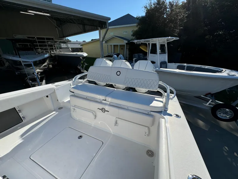 Slide: The Image of 2025 Fountain 38TE boat with white seating, docked near other boats. - 33