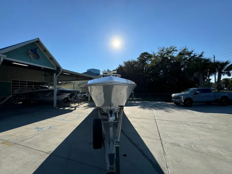 Slide: The Image of 2025 Fountain 38TE boat on trailer under bright sun, parked near a building and trees. - 6