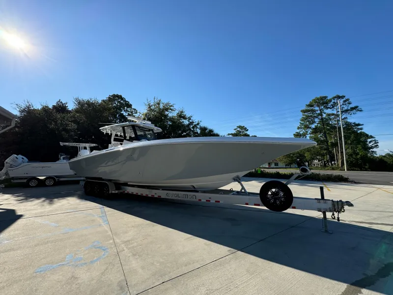Slide: The Image of 2025 Fountain 38TE boat on trailer, parked outdoors under clear blue sky. - 8