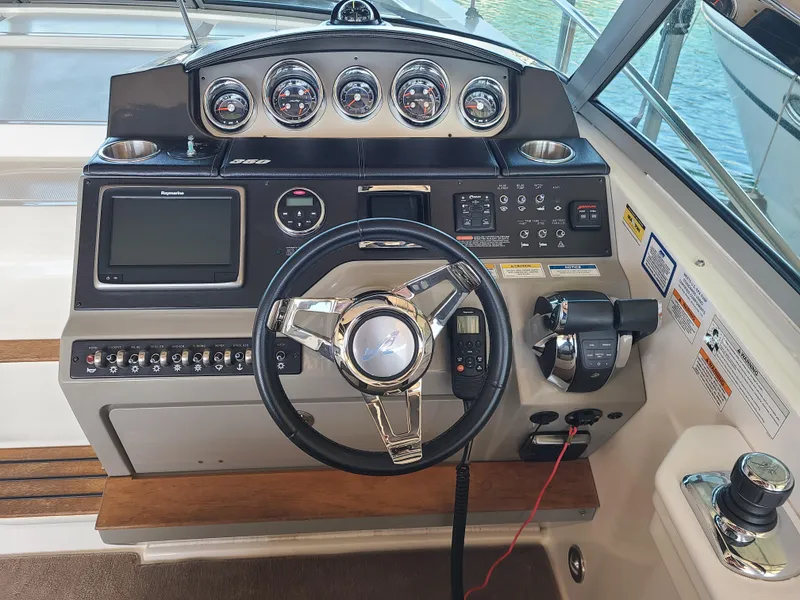 Slide: The Image of Control panel of 2016 Sea Ray 350 Sundancer boat with steering wheel and gauges. - 13