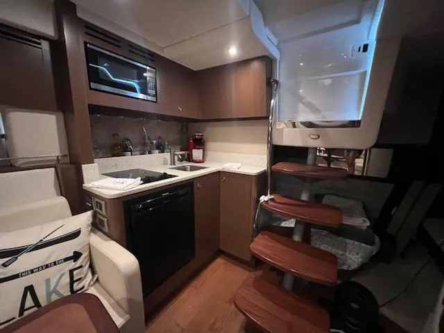 Slide: The Image of Interior of 2016 Sea Ray 350 Sundancer yacht with modern kitchen and wooden stairs. - 20