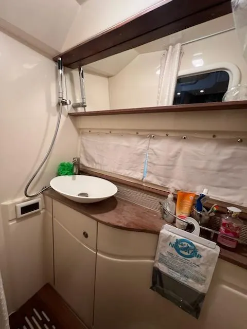 Slide: The Image of 2016 Sea Ray 350 Sundancer bathroom with sink, storage, and window. - 24