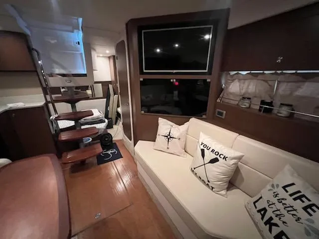 Slide: The Image of Interior of 2016 Sea Ray 350 Sundancer with cozy seating and decorative pillows. - 26