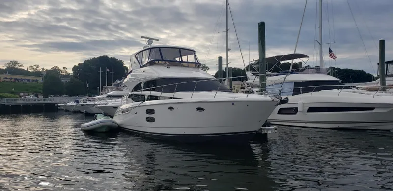 The Image of 2010 Meridian 441 Sedan yacht docked in a marina under cloudy skies. - 0