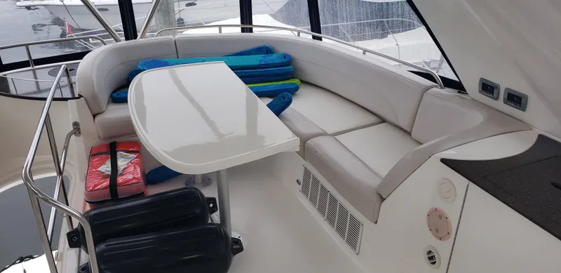 Slide: The Image of 2010 Meridian 441 Sedan yacht interior with cushioned seating and table. - 12