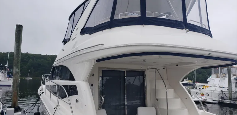 Slide: The Image of 2010 Meridian 441 Sedan yacht docked at marina, featuring spacious upper deck. - 2