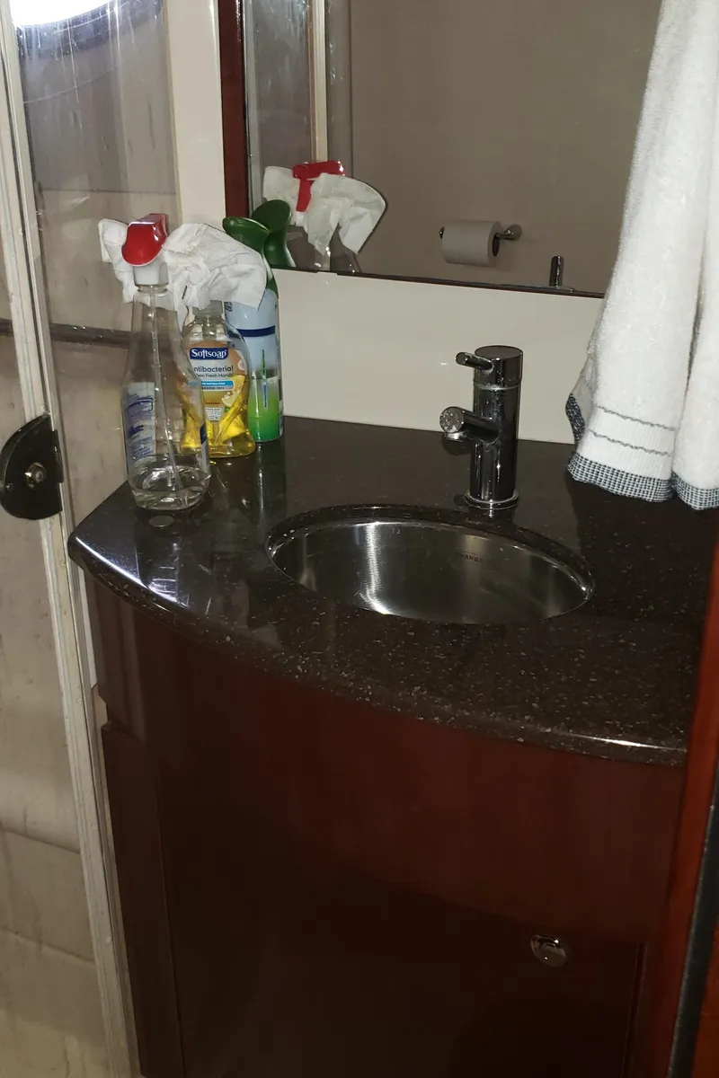 Slide: The Image of Bathroom sink area in a 2010 Meridian 441 Sedan yacht with cleaning supplies. - 24