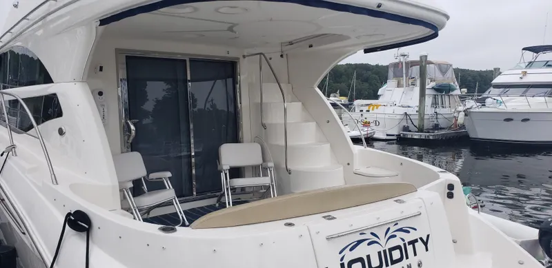 Slide: The Image of 2010 Meridian 441 Sedan yacht docked at marina, featuring spacious deck and seating area. - 3