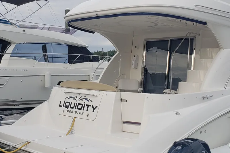 Slide: The Image of 2010 Meridian 441 Sedan yacht docked, featuring spacious deck and sleek design. - 4