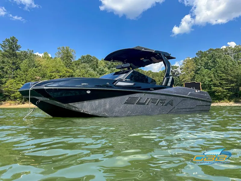 Slide: The Image of 2024 Supra SE boat on a lake with a clear blue sky background. - 13