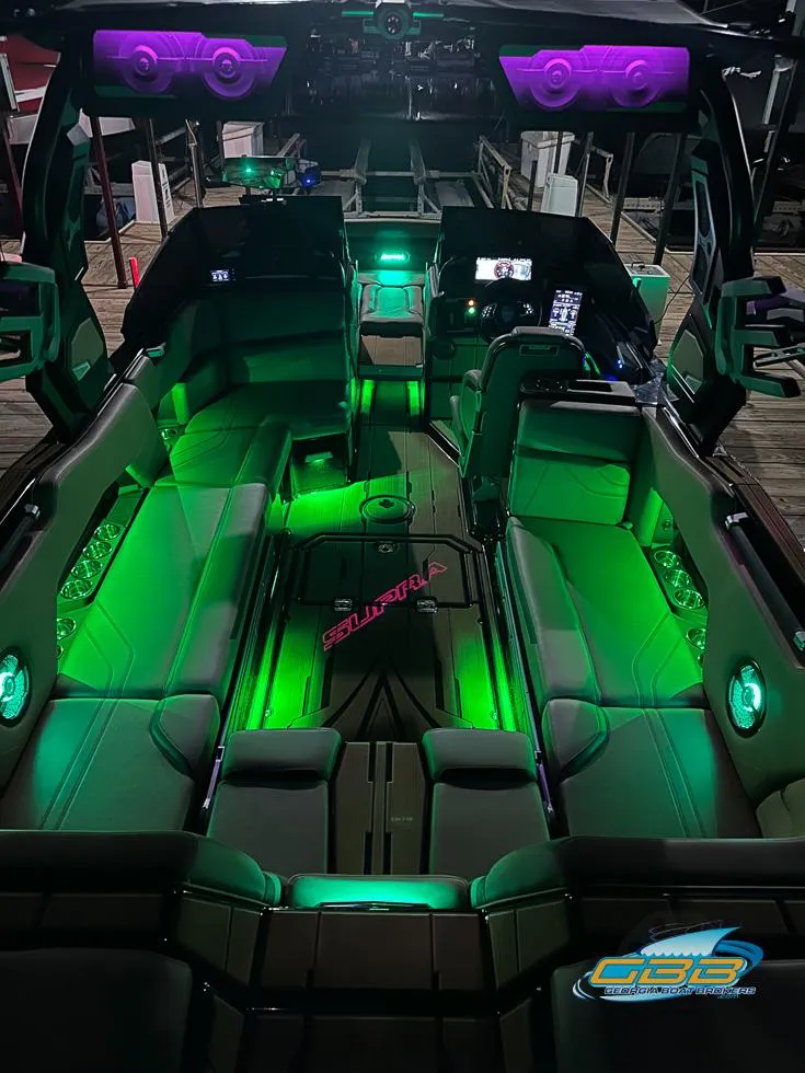 Slide: The Image of 2024 Supra SE boat interior with vibrant green and purple LED lighting. - 38