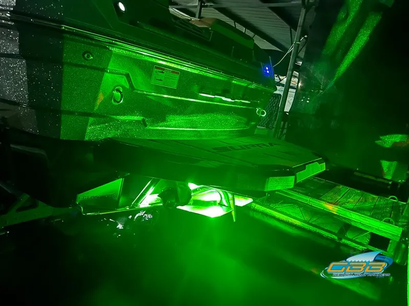 Slide: The Image of 2024 Supra SE boat with vibrant green underwater lighting at night. - 40