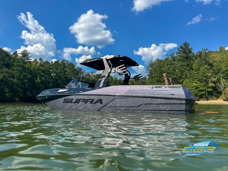 Slide: The Image of 2024 Supra SE boat on a lake, surrounded by trees and blue sky. - 9