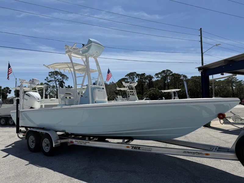 Slide: The Image of 2025 Pathfinder 2600 HPS boat on trailer, displayed outdoors with American flags. - 7