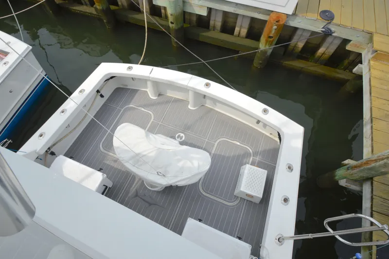 Slide: The Image of 1998 Post 42 Convertible boat docked, featuring spacious deck and covered equipment. - 12