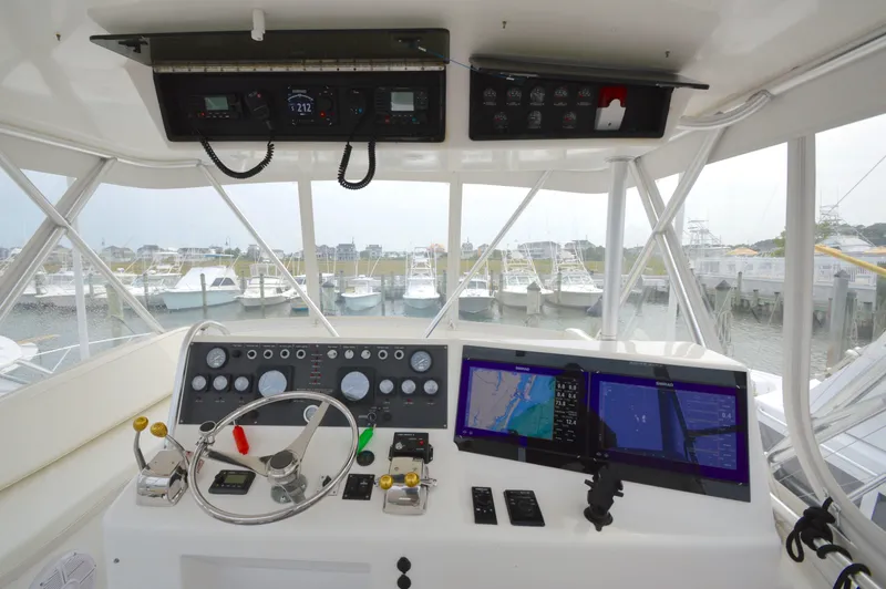 Slide: The Image of 1998 Post 42 Convertible yacht helm with navigation screens and marina view. - 2