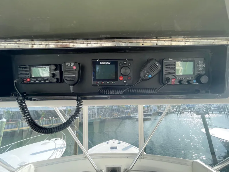 Slide: The Image of Boat cockpit with communication equipment, featuring Simrad and Icom devices, on a 1998 Post 42 Convertible. - 24