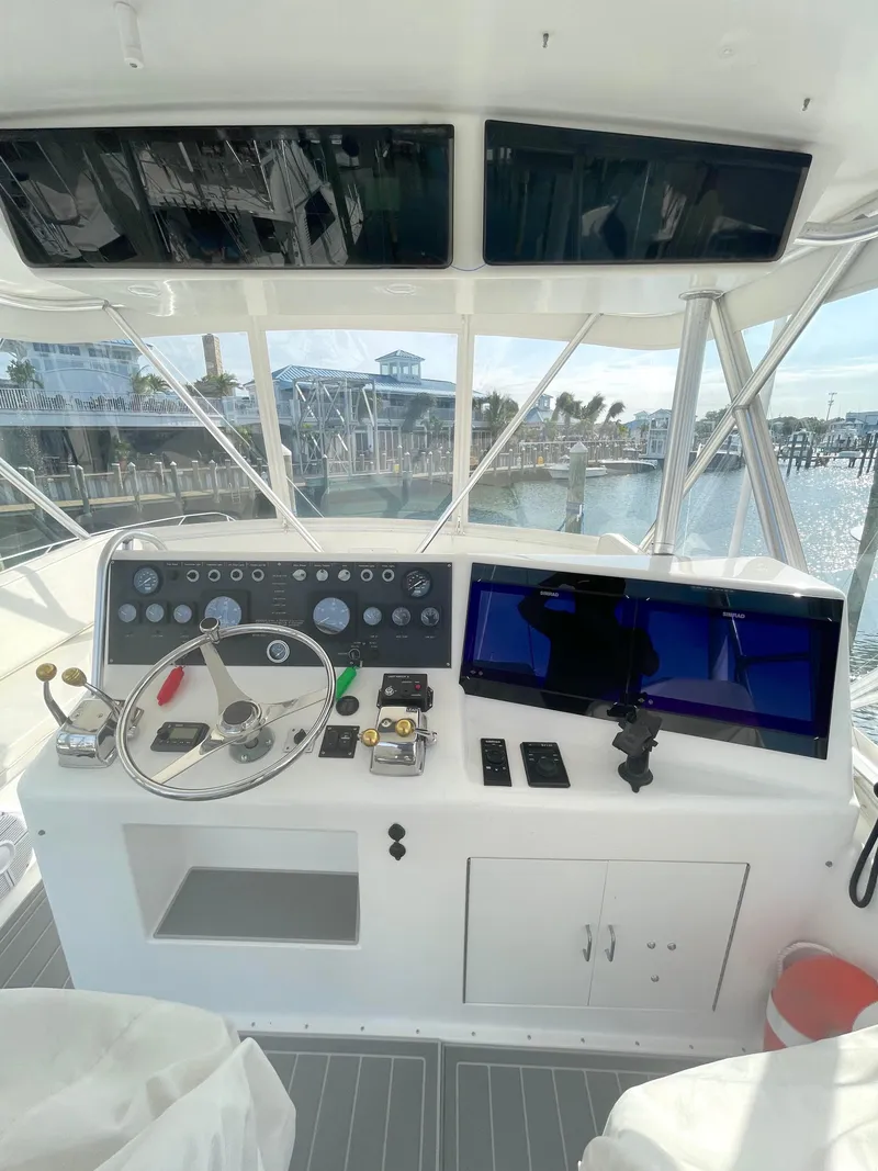 Slide: The Image of 1998 Post 42 Convertible yacht helm with steering wheel and navigation controls. - 25